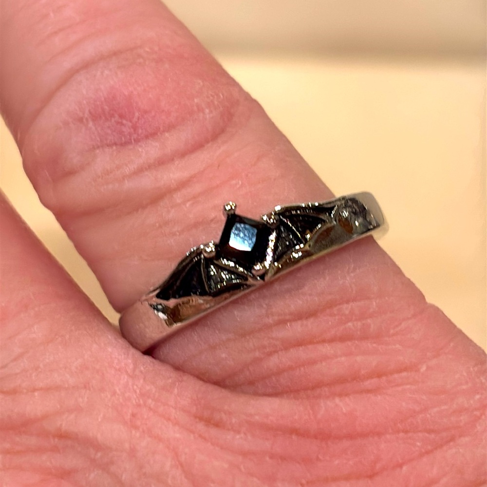 Ring size 7 1/4 adjustable. Silver toned and black faceted glass center.